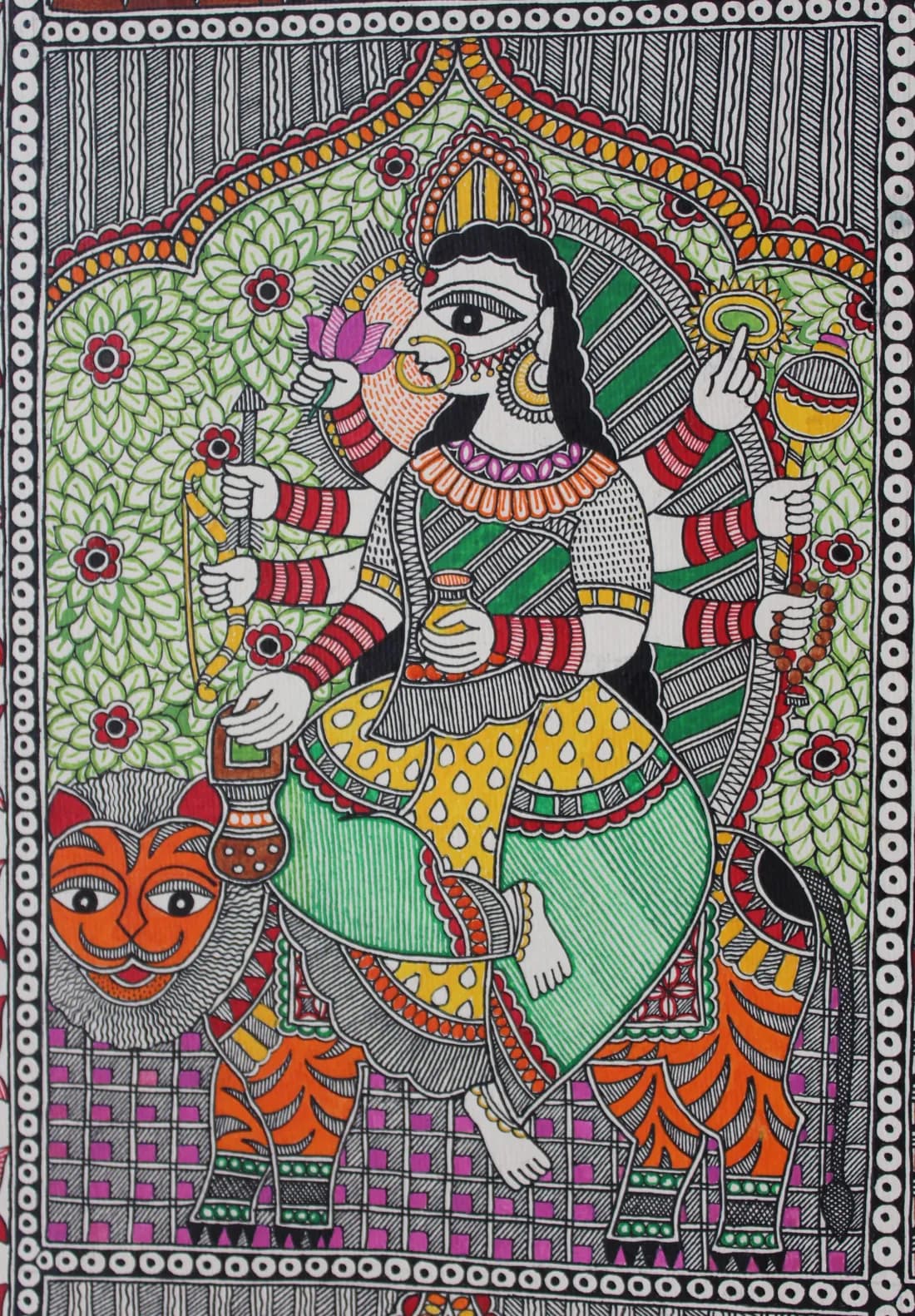 Madhubani painting of a many-armed goddess holding a lotus, mace and rosary, seated on a tiger amid green floral foliage