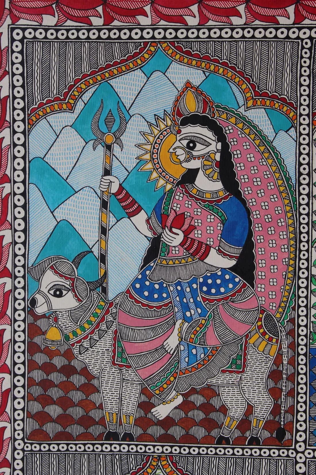 Madhubani painting of a goddess holding a trishul, seated on a bull before stylised blue mountains